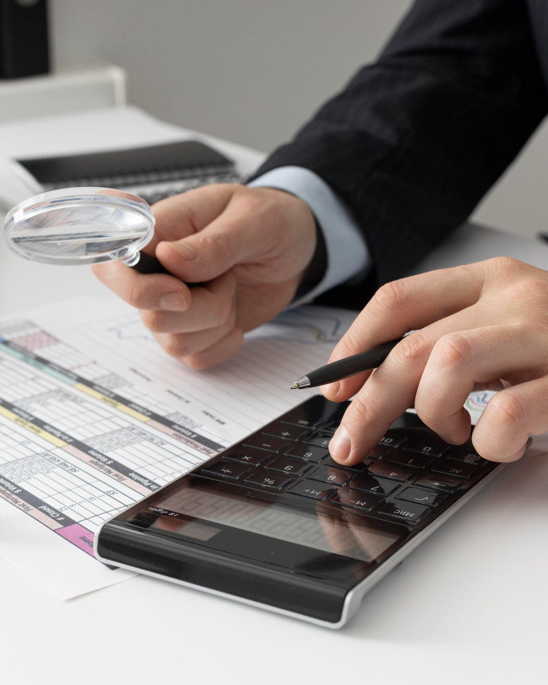 An image that shows a businessman calculating finance numbers using calculator.