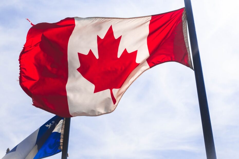An image of Canada flag waving in the blue sky