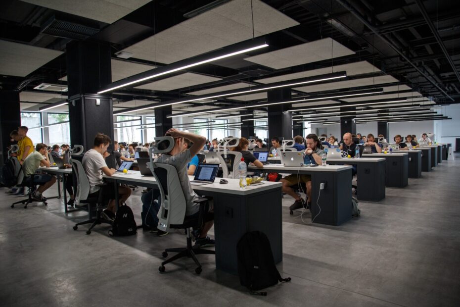 An image of a whole modern office with employees each one sitting on his disk