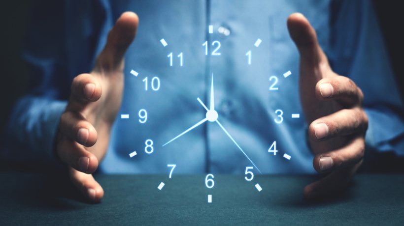 An image of a man holding an imaginary clock between his hands.