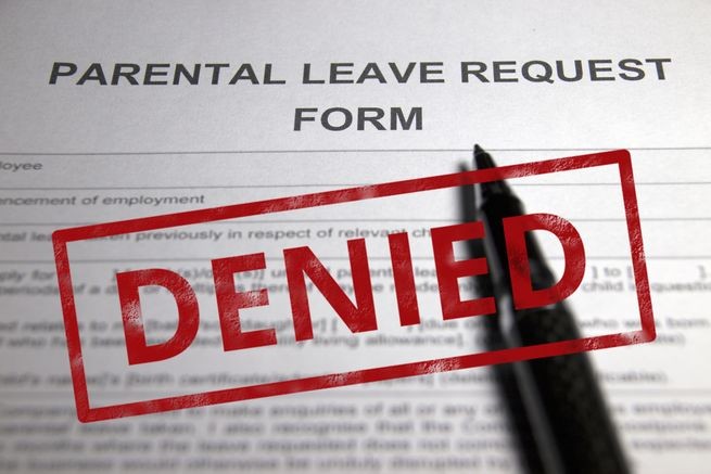 paper with parental leave request, with a pen on it, and it is Reject Employee's Leave Request