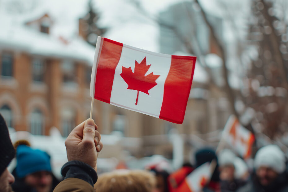 An image of a hand holding small flag of Canada