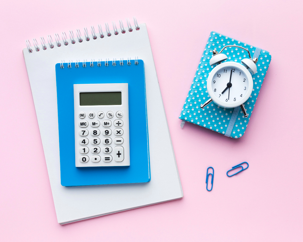 An image with a pink background, calculator, and a small clock.