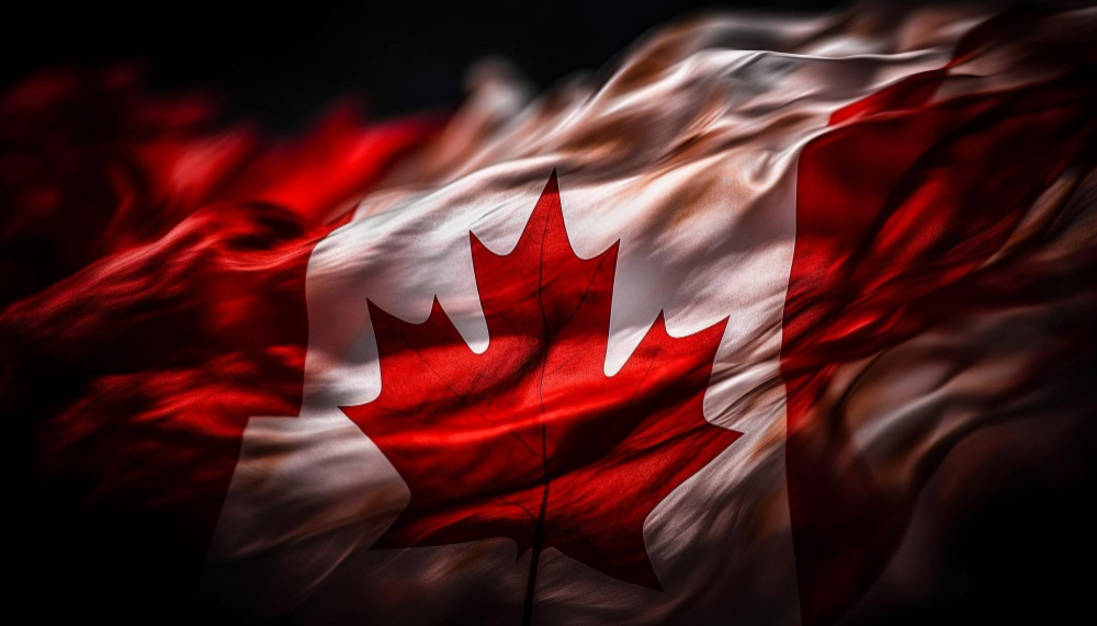 A vibrant, close-up image of the Canadian flag waving in the wind. The red and white colors are vivid, with the iconic red maple leaf prominently displayed in the center. The flag appears dynamic and fluid, with the fabric's texture and motion captured in detail. The background is dark, enhancing the contrast and making the flag's colors stand out even more.