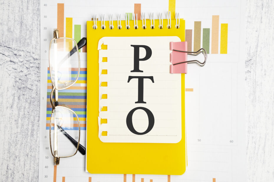 Yellow notebook with 'PTO' written on the cover, placed on a background of colorful charts and graphs, representing the concept of a vacation accrual calculator for tracking paid time off.